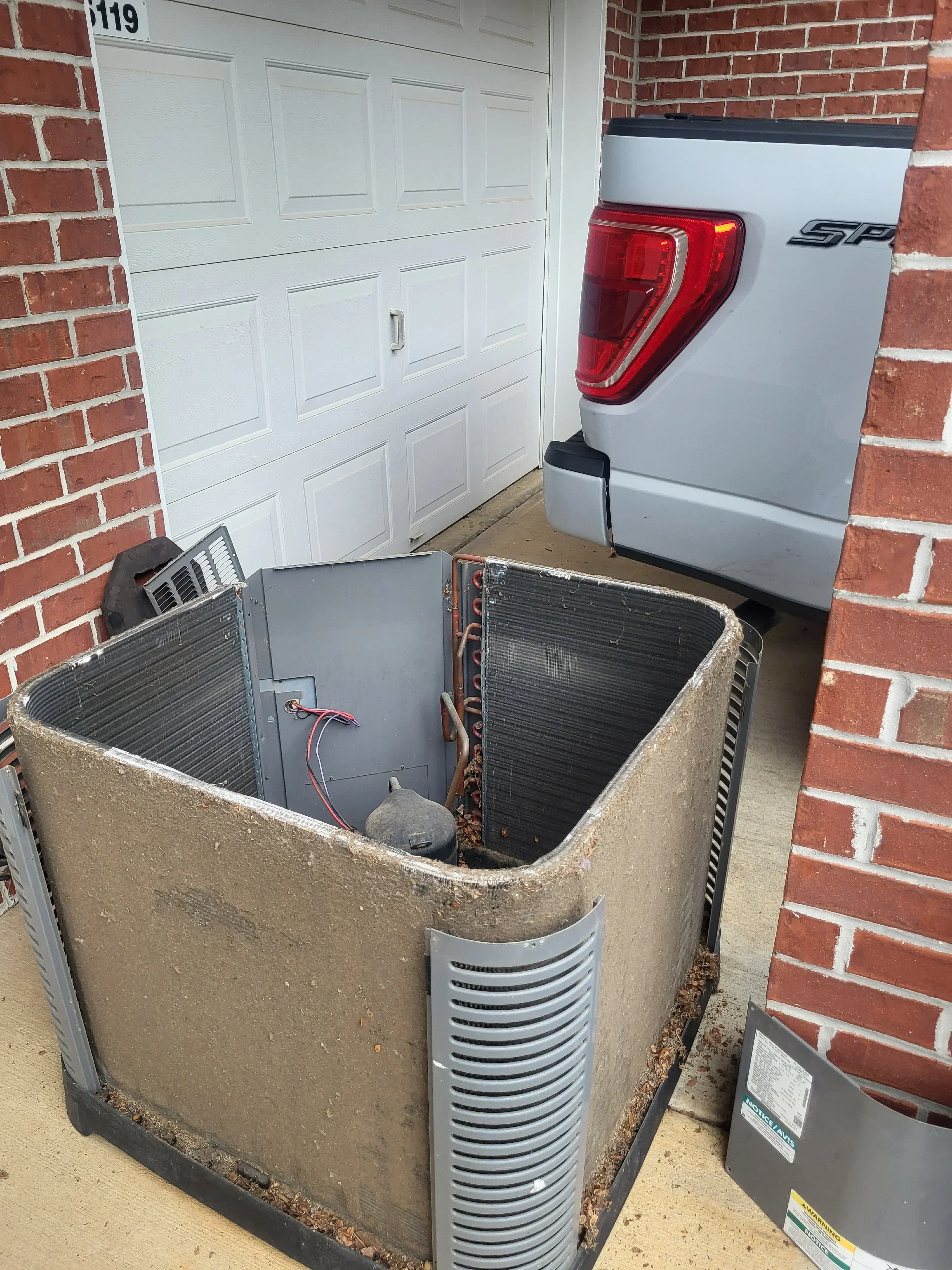 New HVAC unit with metal ductwork, electrical connections, and flexible ducting installed on concrete pad