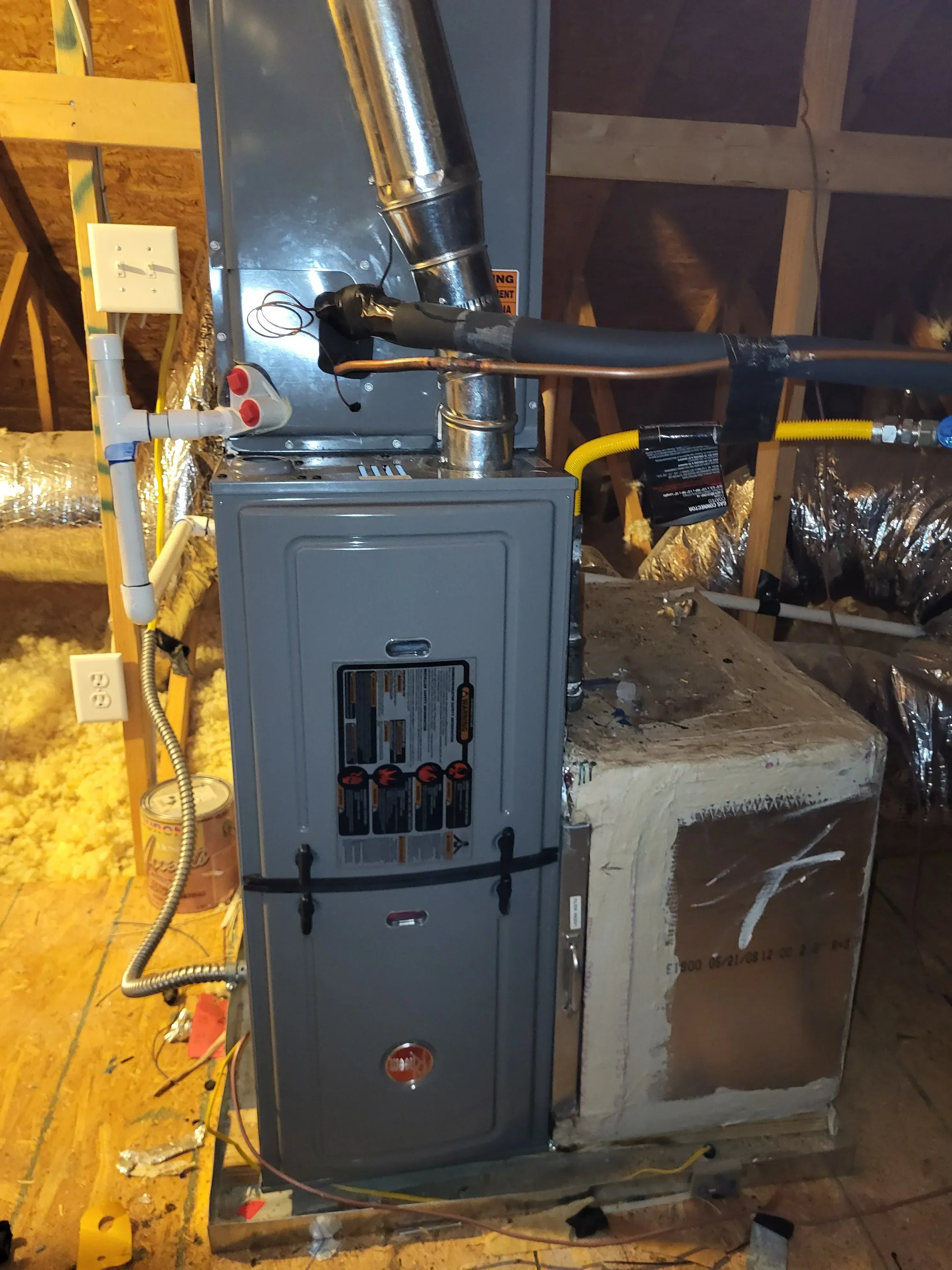 Gas furnace with yellow flex line, electrical panel, and ductwork in basement installation